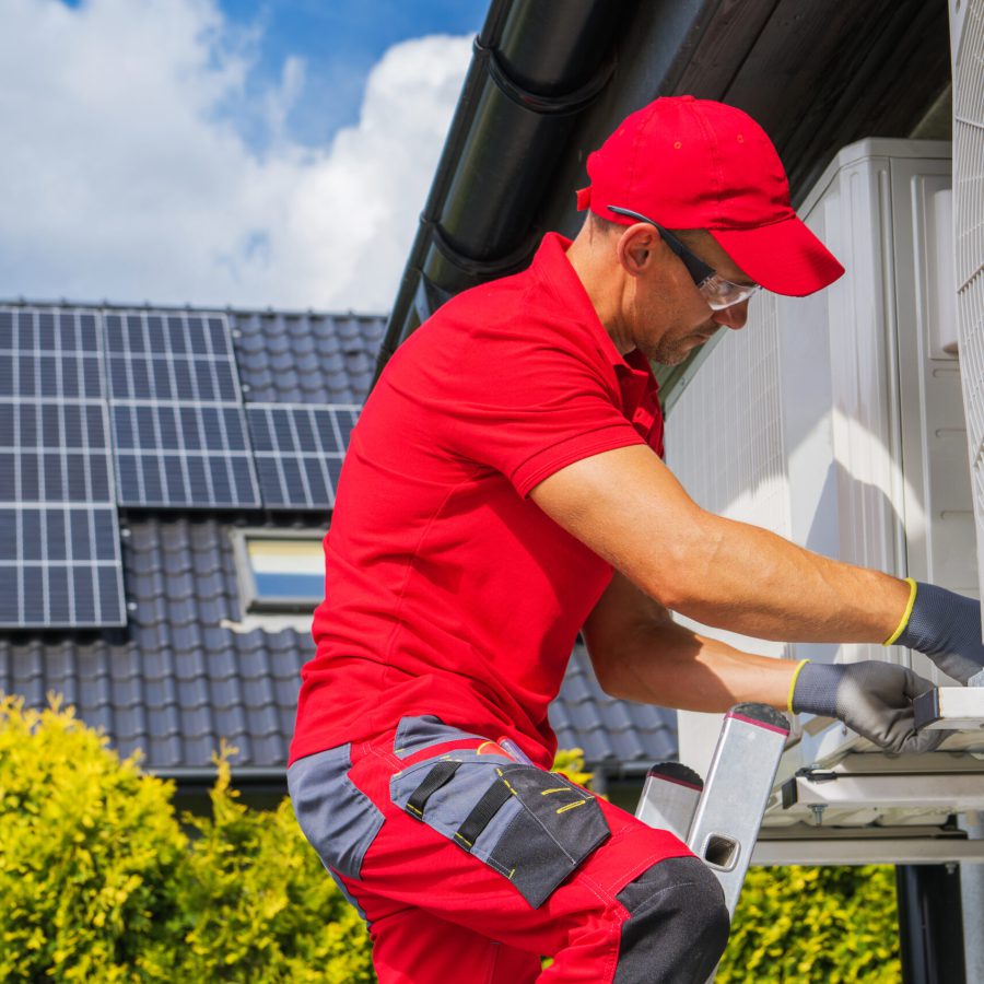 HVAC Worker Performing Heat Pump Maintenance. Device is Transferring Thermal Energy From the Outside Using the Refrigeration Cycle. Home Heating Technologies.